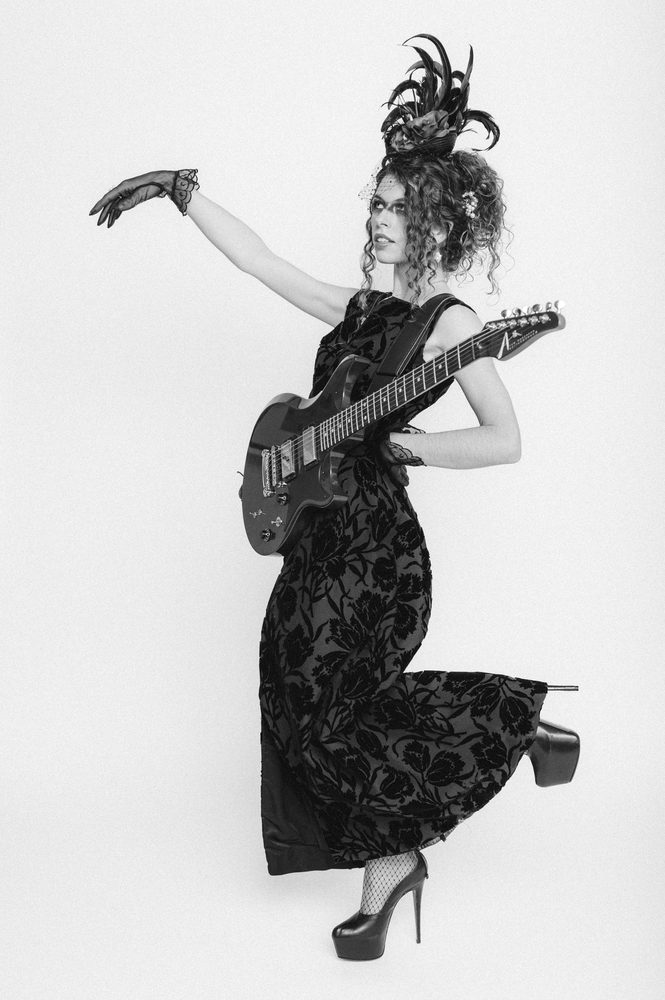 Hannah Wicklund in a black gown with her guitar